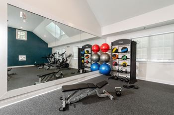 A gym room with a mirror, weights, and exercise equipment. at Spa Cove Apartments, Annapolis, 21403